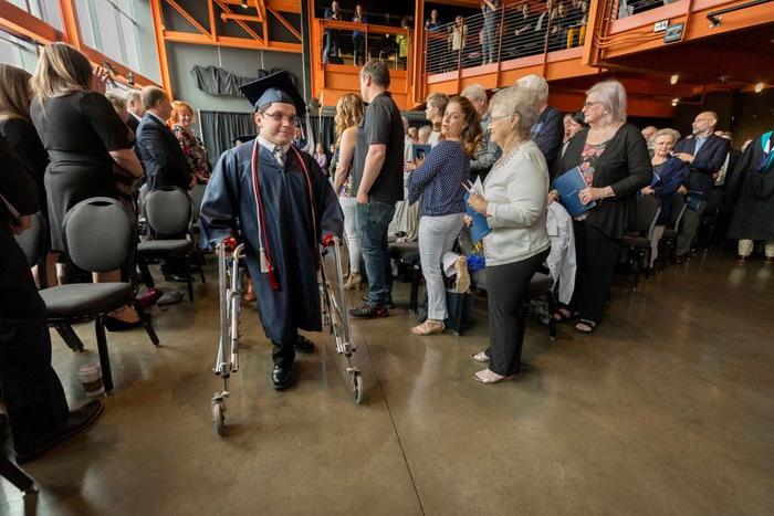 man processing in using a walker