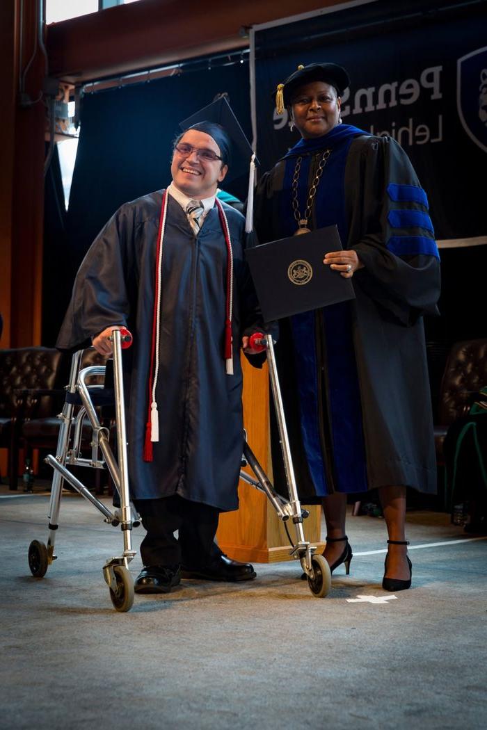 a woman and a man with a walker on stage