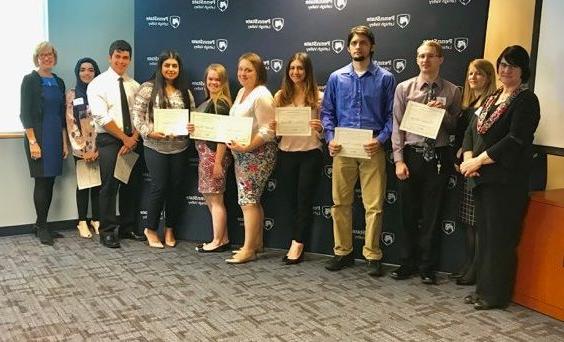 Group of students with faculty members displaying their certificates