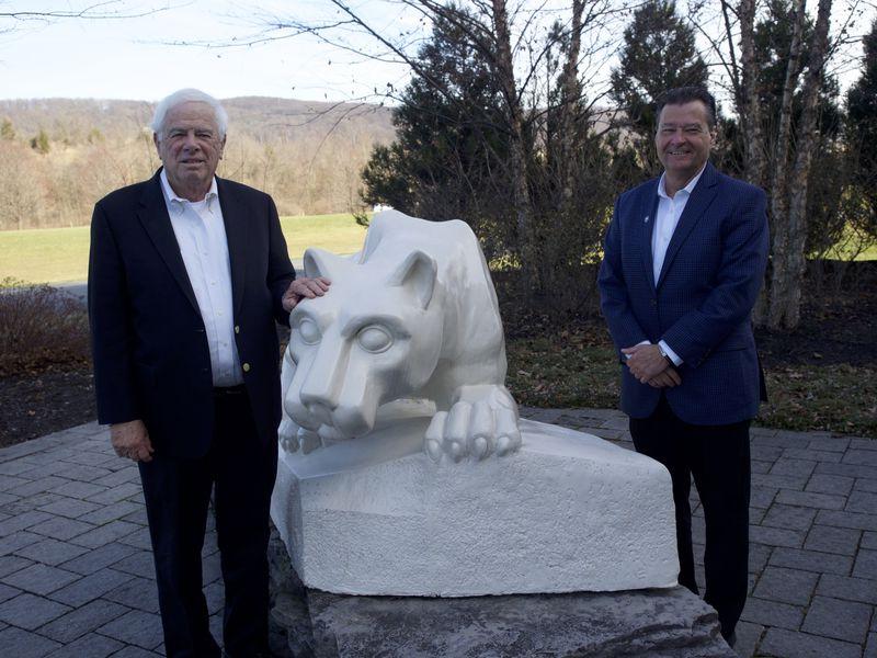 Two men flank Nittany Lion Shrine