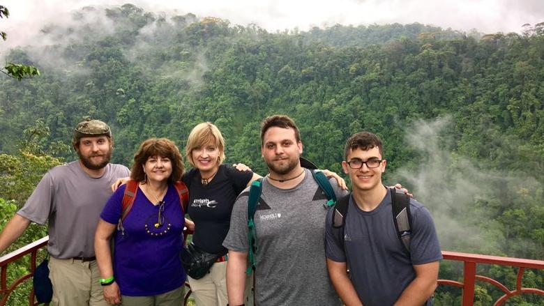 people standing in front of rainforest