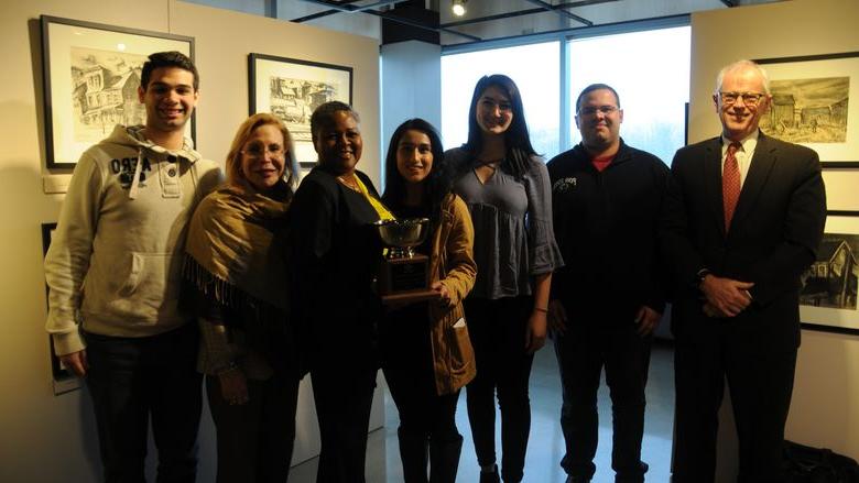 Winning debate team presented trophy to Dr. Richardson and posed in art gallery for group photo