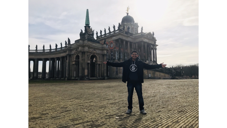 student in front of a German building