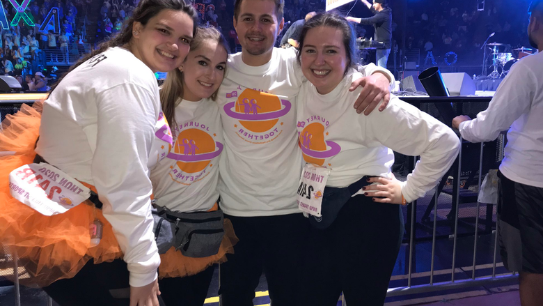 four people in matching shirts on arena floor