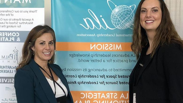 two women in front of a research poster